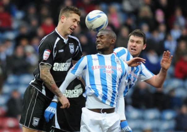 Huddersfield's Theo Robinson and Anthony Gerrard challenge Ipswich's Luke Chambers for the ball.