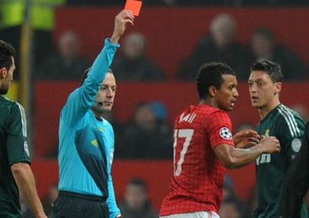 Manchester United's Nani receiving a red card from referee Cuneyt Cakir during the UEFA Champions League match at Old Trafford