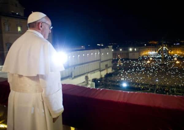 Pope Francis looks at the crowd from the central balcony of St. Peter's Basilica at the Vatican