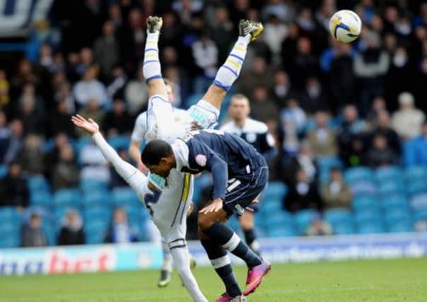 Huddersfield player Jermaine Beckford tangles with Lee Peltier
