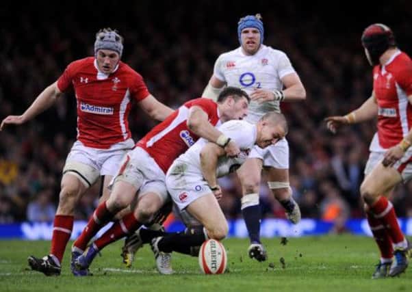 England's Mike Brown (centre right) fumbles the ball as he is tackled by Wales Alex Cuthbert (centre left)