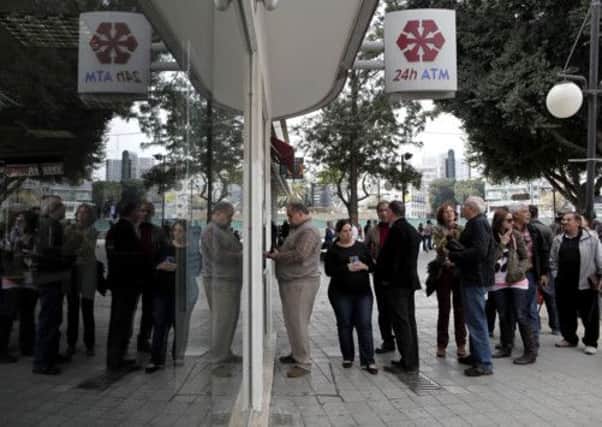 People queue at an ATM outside a Cyprus bank.