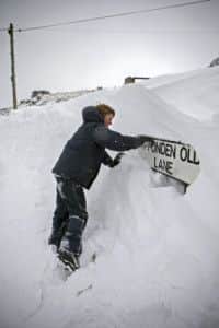 Twelve year-old Ben Collier uncovers a road sign completely blocked by 10 foot drifts near to his home in Ripponden on the West Yorkshire Pennines.