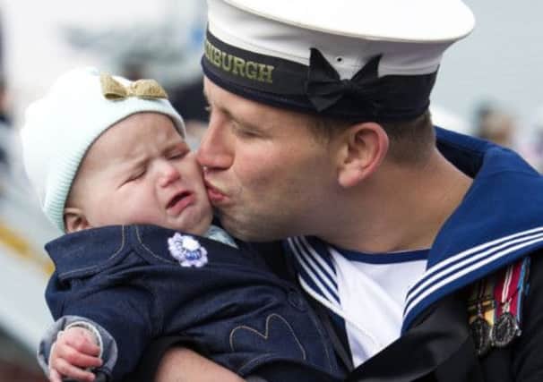 Leading Seaman Kyle Broomhead from Barnsley doesn't quite get the reaction he'd hoped for as he kisses his daughter six month old Phoebe after returning from deployment aboard HMS Edinburgh