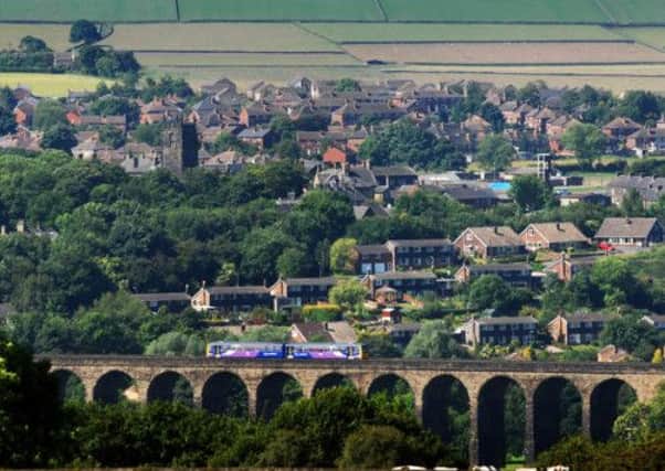 A train passes over the viaduct at Penistone, near Sheffield and Dr Richard Beeching, below.
