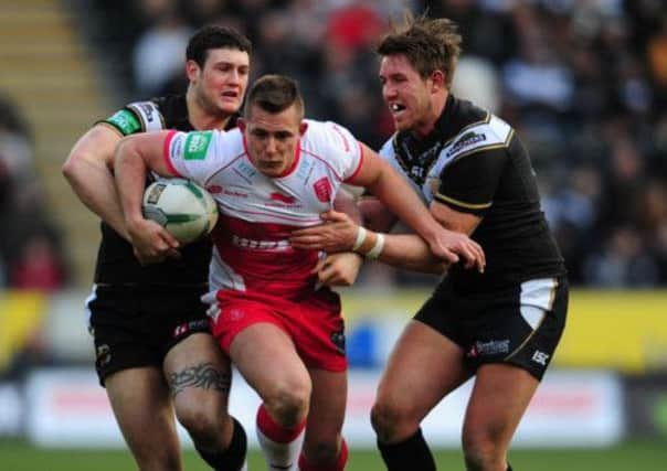 Hull Kingston Rovers' Greg Eden is tackled by Hull FC's Jay Pitts (left) and Paul Johnson