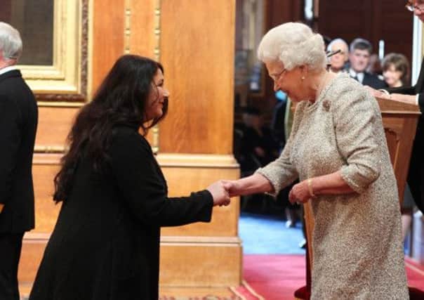 Kate Bush receives her CBE from the Queen