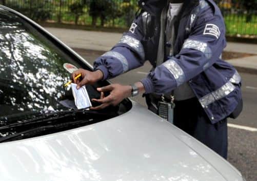 An attendant issues a parking ticket