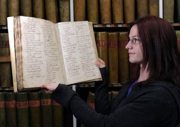 Archivist Jenny Brierley with a recipe book from the early 19th Century.