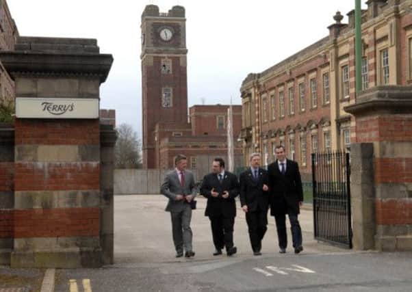Paul Newman, of David Wilson Homes, Coun James Alexander, leader of York City Council, Coun Dave Merrett, cabinet member for transport and planning substainability, and Ben Ward, from developers Henry Boot, walk through the gates of the former Terry's factory in York