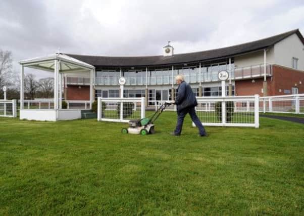 Sylvia Merrington, who is believed to be the only female full-time racecourse ground staff worker in the country, mowing the parade ring as final preparations got underway on Beverley Westwood