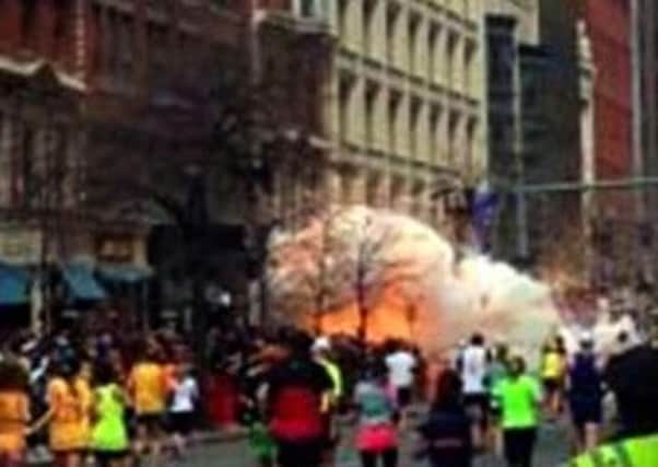 Spectators and runners run from what was described as twin explosions that shook the finish line of the Boston Marathon. AP Photo/WBZTV