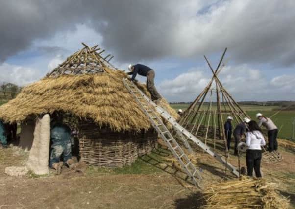 English Heritage volunteers construct one of three Neolithic houses near Salisbury, Wiltshire.