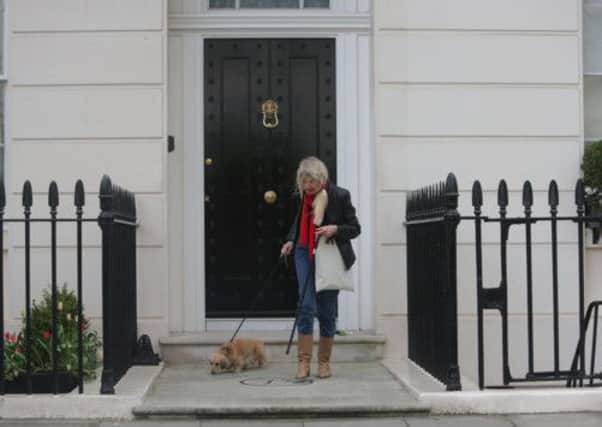 A woman walks away with after laying flowers at the home of former Prime Minister Margaret Thatcher in Central London.