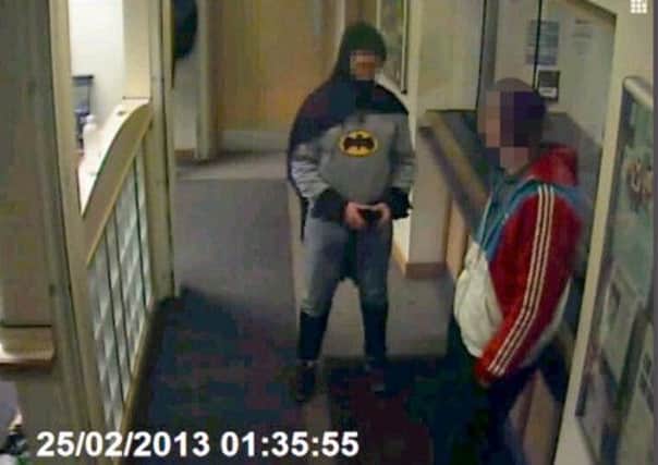 Police CCTV of a man dressed as Batman who walked into Trafalgar House police station in Bradford and handed over his friend.