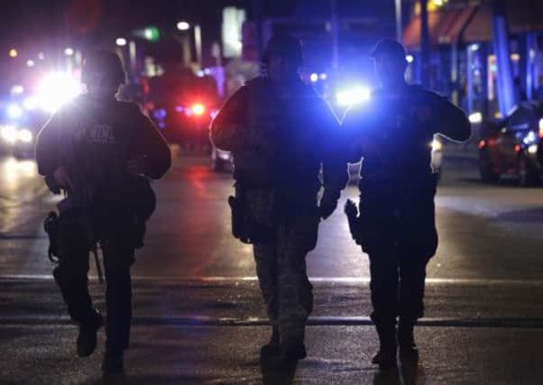 Officers wearing tactical gear arrive at the Watertown neighborhood of Boston