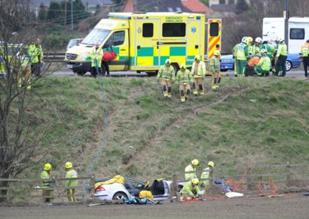 Emergency services at the scene of a car which rolled down the embankment of the M1
