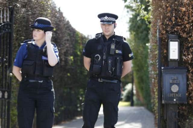 Police officers outside the gates leading onto the driveway of the home of Coronation Street actor Bill Roache in Cheshire.