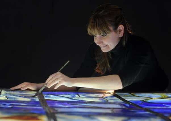 Helen Whittaker, Creative Director at Barley Studios, York, putting the finishing touches to a section of one of the stain glass windows