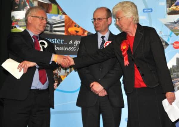 Labour candidate Ros Jones (right) is congratulated by outgoing mayor Peter Davies after she was voted Mayor of Doncaster after the counting of votes at Doncaster Racecourse.
