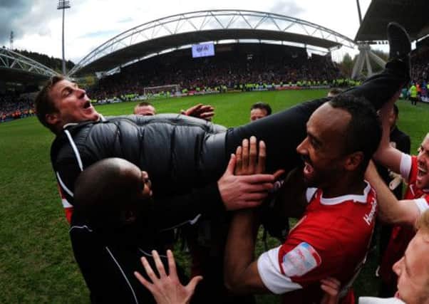 The Barnsley players carry their manager David Flitcroft after escaping relegation.
