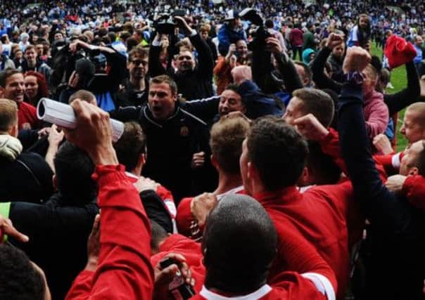 Barnsley manager David Flitcroft and his players celebrate after hearing the Peterborough result.