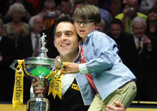 Ronnie O'Sullivan holds the trophy and his son Ronnie after winning the final match