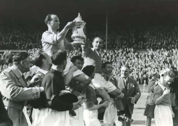 Harry Johnston and Stanley Matthews hold the FA cup aloft.