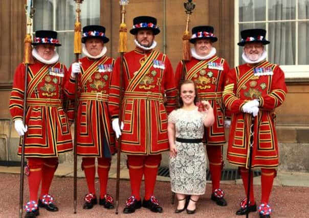 Paralympic swimmer Ellie Simmonds with members of the Yeoman of the Guards after she received her OBE from the Prince of Wales