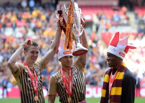 Stephen Darby, Nahki Wells and Kyel Reid with the play-off trophy.