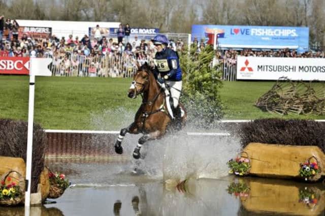 Zara Phillips on High Kingdom hits the flag on the first of two brush jumps and causes a splash in the Lake while taking part in the Cross-Country during day four of the Badminton Horse Trials