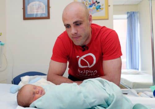 Bradford Bulls star Adrian Purtell with two-week-old Arthur MacLean Rumboll, who has just had heart surgery.