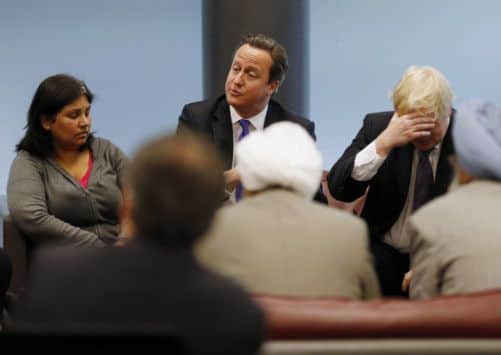 David Cameron and Mayor of London Borris Johnson speak to members of the local community, during a visit to Woolwich