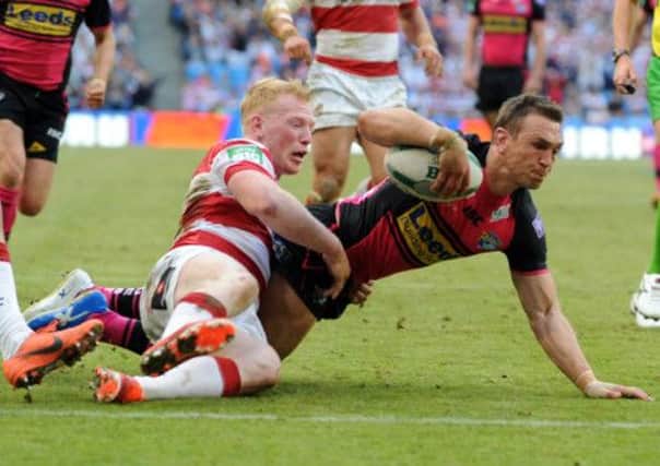 Kevin Sinfield scores for Leeds as Liam Farrell fails to hold on. (Picture: Steve Riding)..