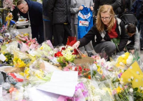 Ingrid Loyau-Kennett, who was praised for her bravery in calmly talking to one of the attackers, looks at the floral tributes outside the Royal Artillery Barracks, in Woolwich, east London.