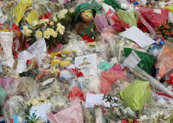 A papier mache figure of a solder is placed with the flowers and cards close to the scene of drummer Lee Rigby's murder.