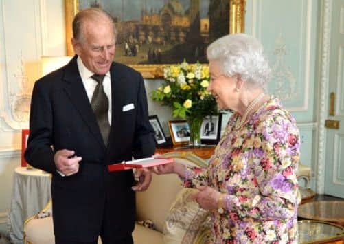 The Queen presents the Duke of Edinburgh with New Zealand's highest honour, the Order of New Zealand at Buckingham Palace, yesterday