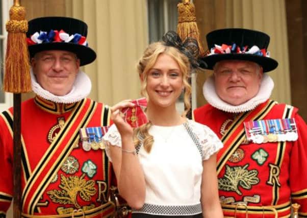 Cyclist Laura Trott with members of the Yeoman of the Guard, after receiving her OBE