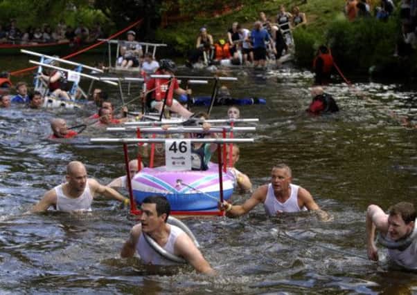 Teams crossing the river Nidd in the annual  Knaresborough bed race.