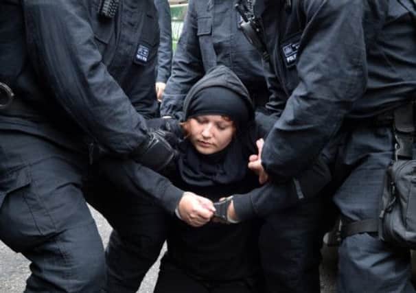 Police restrain a protester in Soho, central London