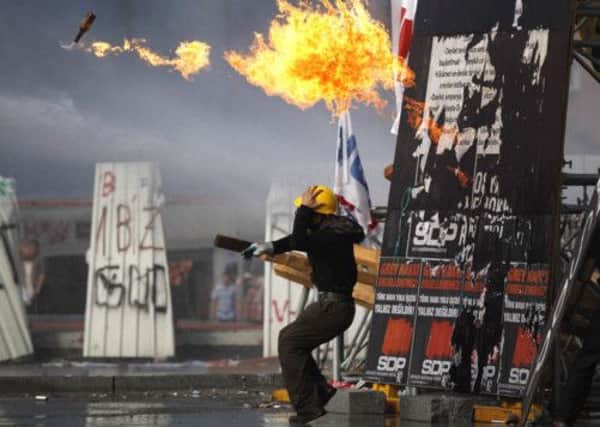 A protester throws a petrol bomb towards riot policemen during clashes in Taksim Square in Istanbul