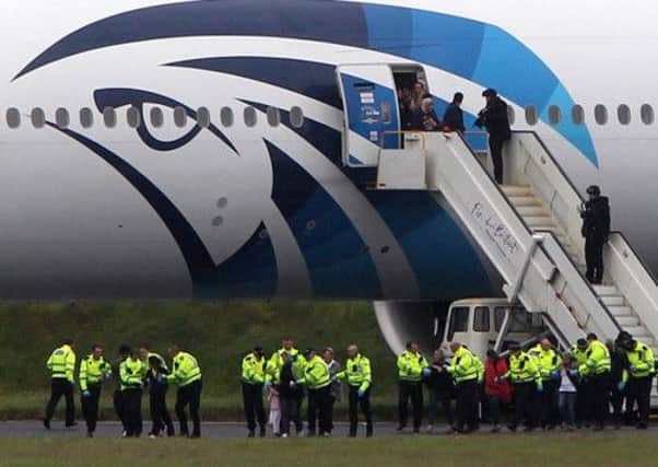 Passengers leave the Egyptair aircraft flying from Cairo to New York after it was diverted to Prestwick Airport, Ayrshire