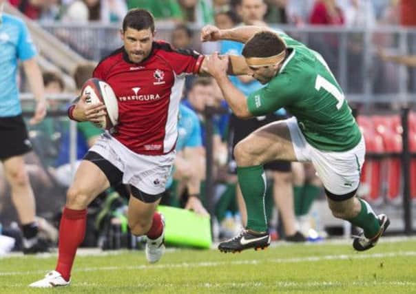 Team Canada wing James Pritchard, left, breaks a tackle against Team Ireland wing Fergus McFadden