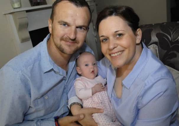 Christopher and Sara Sills with their baby daughter