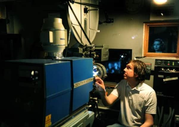 Adam Keay, projectionist at York's City Screen checking the films in readiness for the  reopening of York City Screen