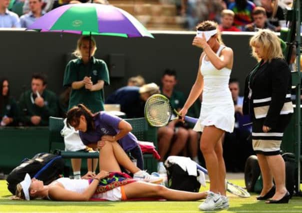 Russia's Maria Sharapova is treated for an injury during her match against Portugal's Michelle Larcher De Brito