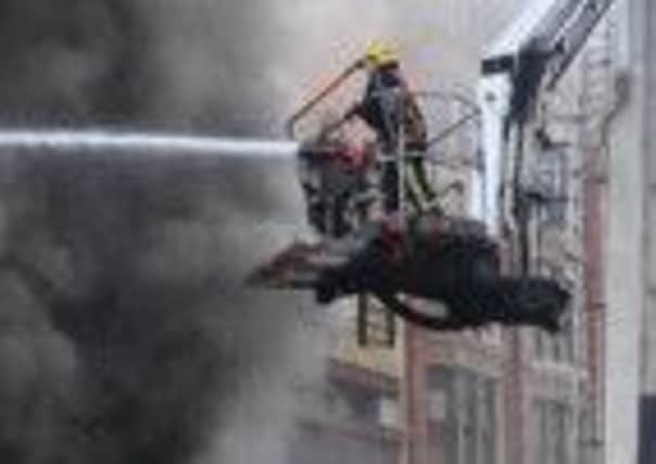 Firefighters tackling a major fire in a shop in Manchester city centre, where a firefighter has died after being pulled from the blaze.