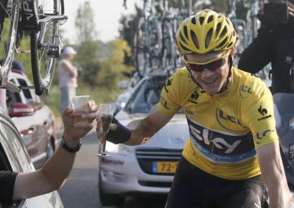 Christopher Froome of Britain, wearing the overall leader's yellow jersey, toasts with his team director