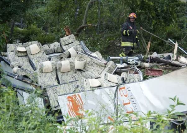 A firefighter looks at the wreckage of a bus which crashed off a highway near Avellino, southern Italy
