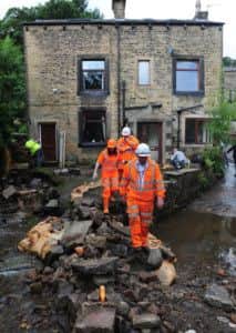 Engineers examine the damage left by flash floods in Walsden, near Todmorden